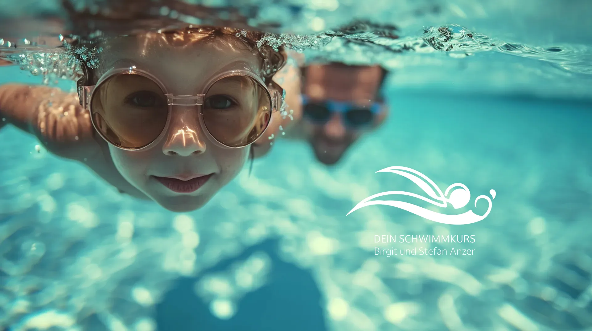 Kind schwimmt unter Wasser mit Schwimmbrille im Schwimmkurs mit Begleitperson